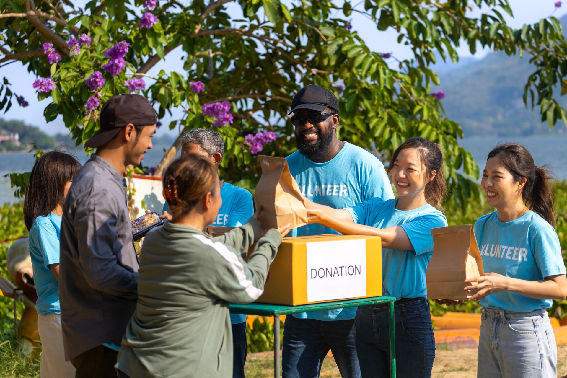 Team of humanitarian aid volunteer is distributing basics survival kit relief bag to the homeless and refugee people in the conflict area to help solving poverty and spreading kindness concept