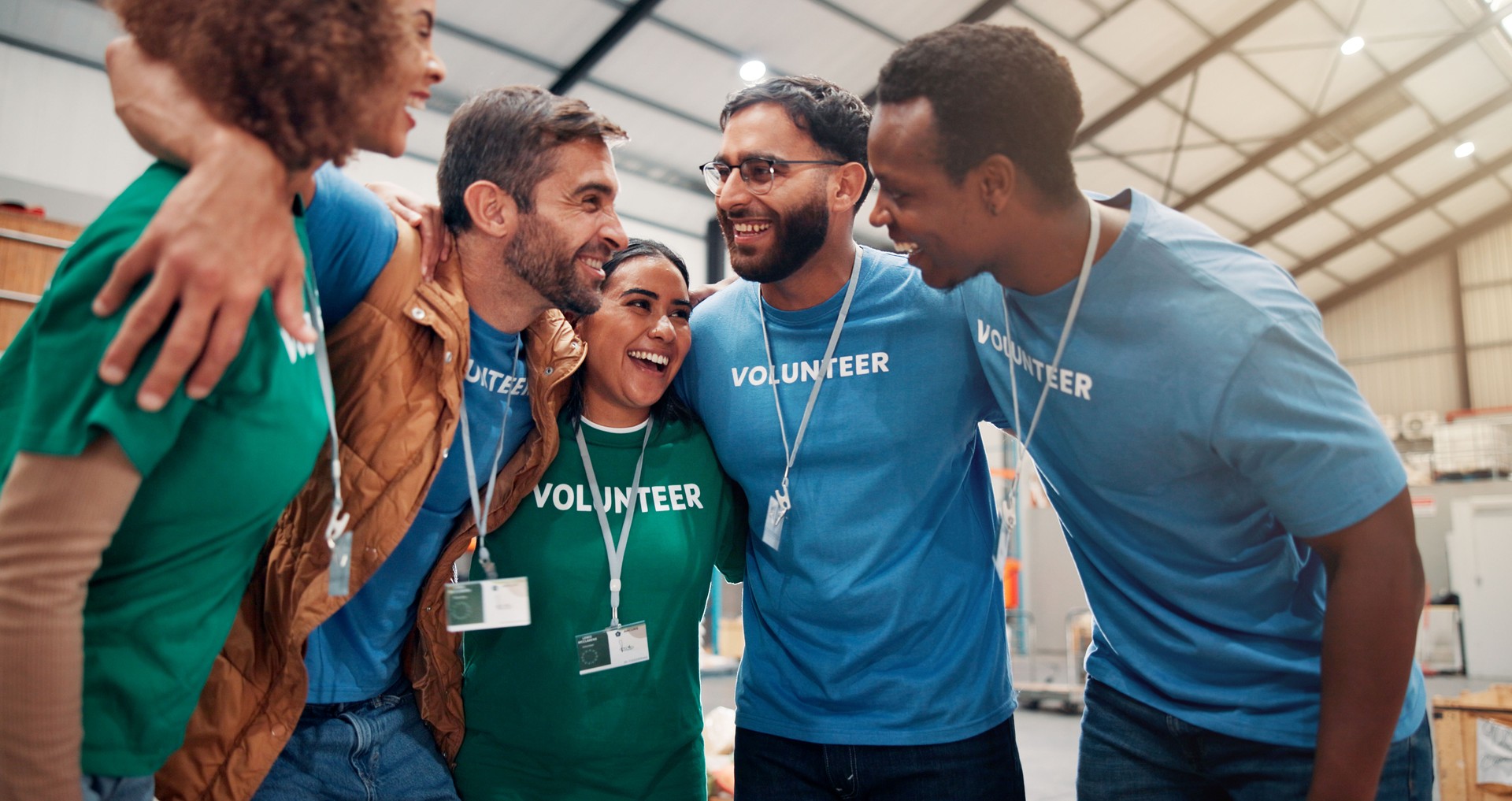 People, volunteer and huddle for support of donation, team building and trust for community service. Smile, staff and hug for ngo meeting of charity event, social responsibility and group solidarity