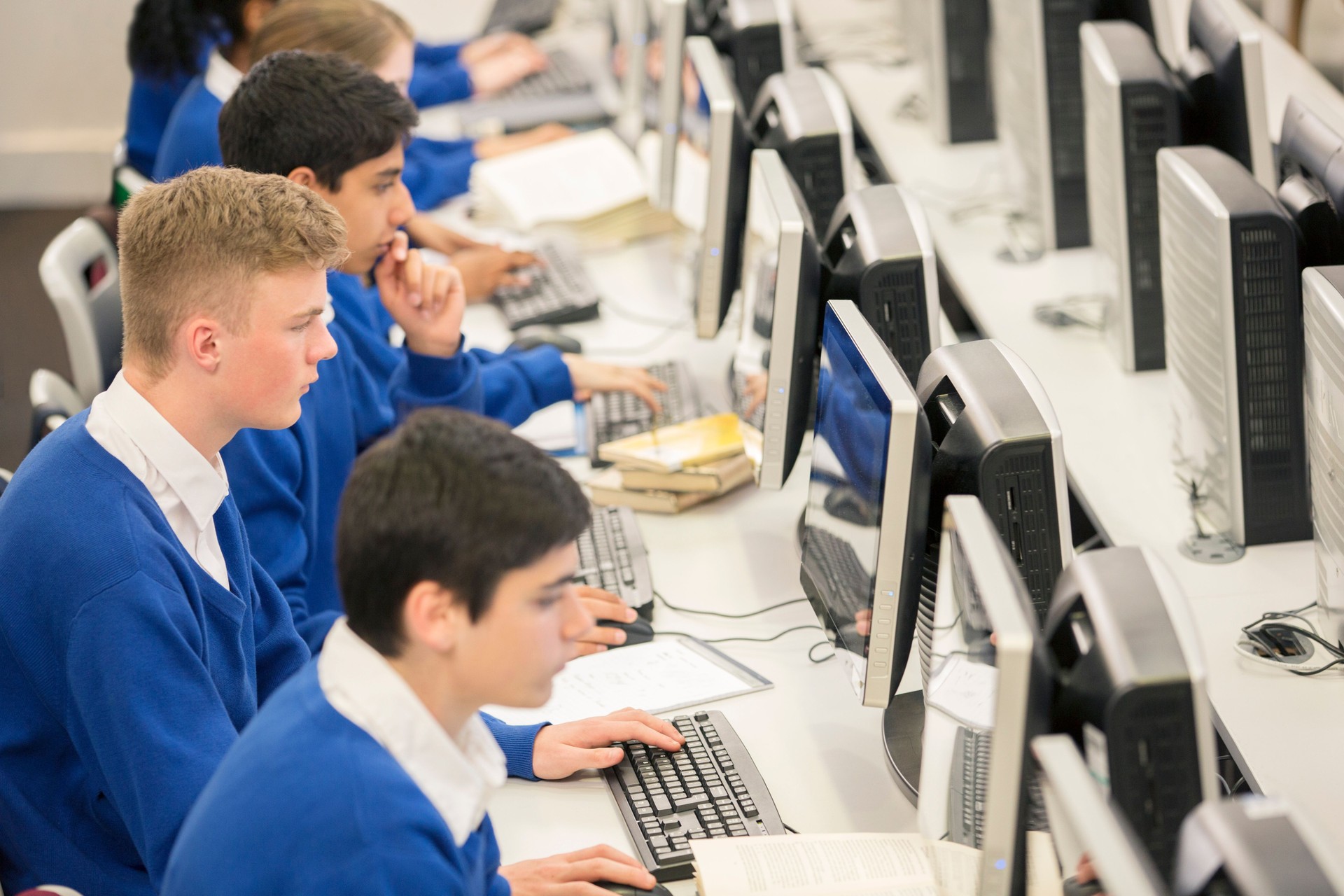 Teenage students using computers in computer room